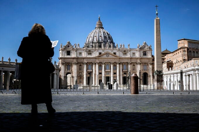 Una mujer reza sola ante la Basílica de San Pedro del Vaticano/EFE