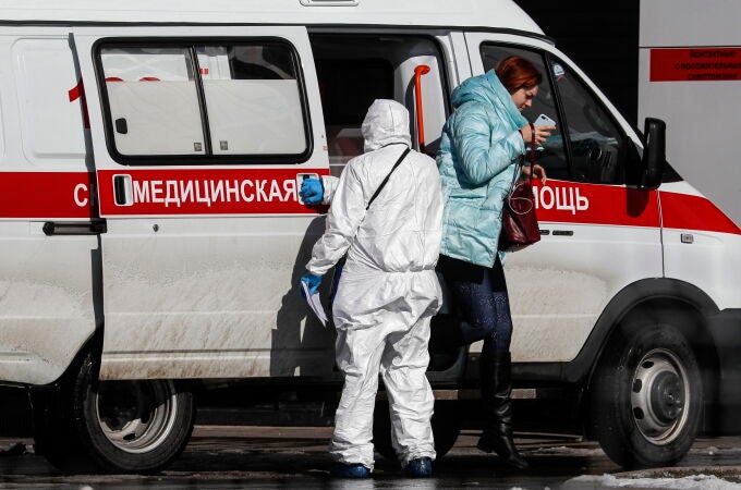 Un sanitarioi con un traje especial traslada a una pacietne al complejo hospitalario de Kommunarka en Moscú