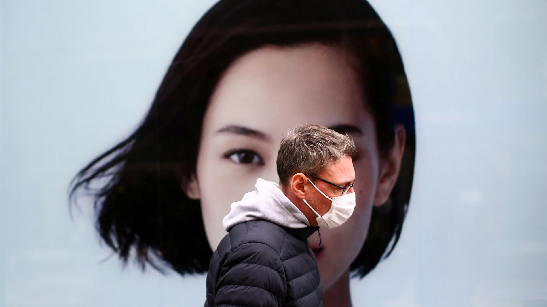 A man, wearing a protective mask following an outbreak of the coronavirus disease (COVID-19), walks in Tokyo