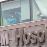 Sanitarios del Hospital de La Paz totalmente protegidos saludan y agradecen el apoyo desde una de las ventanas del centro donde se lucha contra el coronavirus, en Madrid