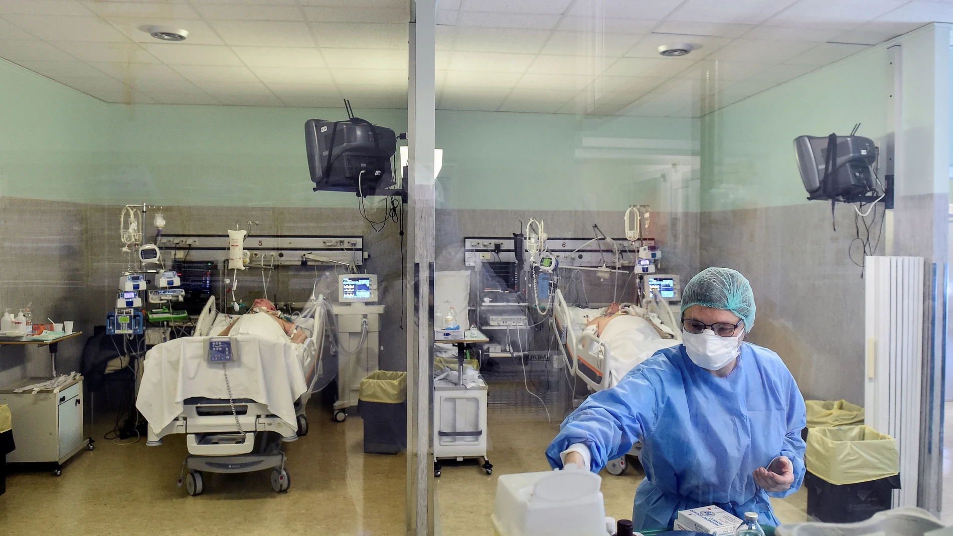 Medical worker wearing a protective mask and suit treats patients suffering from coronavirus disease (COVID-19) in an intensive care unit at the Oglio Po hospital in Cremona