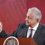 El presidente de México, Andrés Manuel López Obrador, muestra una estampa con un trébol de seis hojas para protegerse contra el coronavirus/EFE