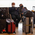 Pasajeros protegidos con mascarilla esperan un vuelo en el aeropuerto de Barajas
