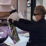 Una mujer realiza una compra en el mercado de abastos de la calle Feria en Sevilla, durante el estado de alarma por coronavirus