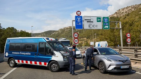 Los Mossos d'Esquadra realizan un control de vehículos, en el peaje de Sitges , para velar por el cumplimiento del confinamiento