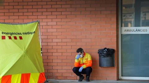 GRAF9851. IGUALADA (BARCELONA), 20/03/2020.- Un sanitario descansa en el exterior del Hospital de Igualada, este viernes cuando la primera enfermera diagnosticada de coronavirus en esta localidad barcelonesa ha negado que asistiera a la comida de profesionales sanitarios que, según el secretario de Salud Pública de Cataluña, Joan Guix, fue el origen del brote que ha obligado a confinar desde hace una semana la Conca d'Òdena, donde han fallecido ya 24 personas. EFE/Susanna Sáez