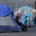 Un &quot;homeless&quot; a la entrada de su tienda en un campamento de Sacramento, en California
