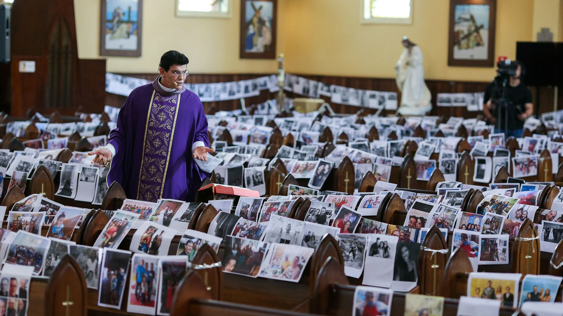 Catholic priest Manzotti conducts a mass, broadcast live on television, with photos of the faithful over the church's banks during the coronavirus disease (COVID-19) outbreak in Curitiba