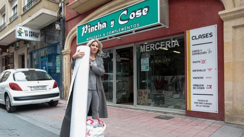 La propietaria de la mercería Pincha y Cose de León, Sonia Llamazares, recibe materiales de voluntarios para fabricar mascarillas y batas de protección