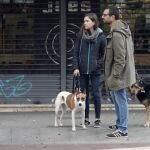 Un miembro del cuerpo de los Mossos d'Esquadra recuerda la normativa de confinamiento a dos ciudadanos en el barrio de Sants