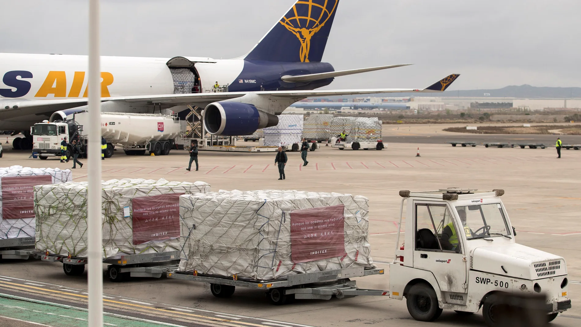 Operarios descargan material sanitario traído por Inditex procedente de China