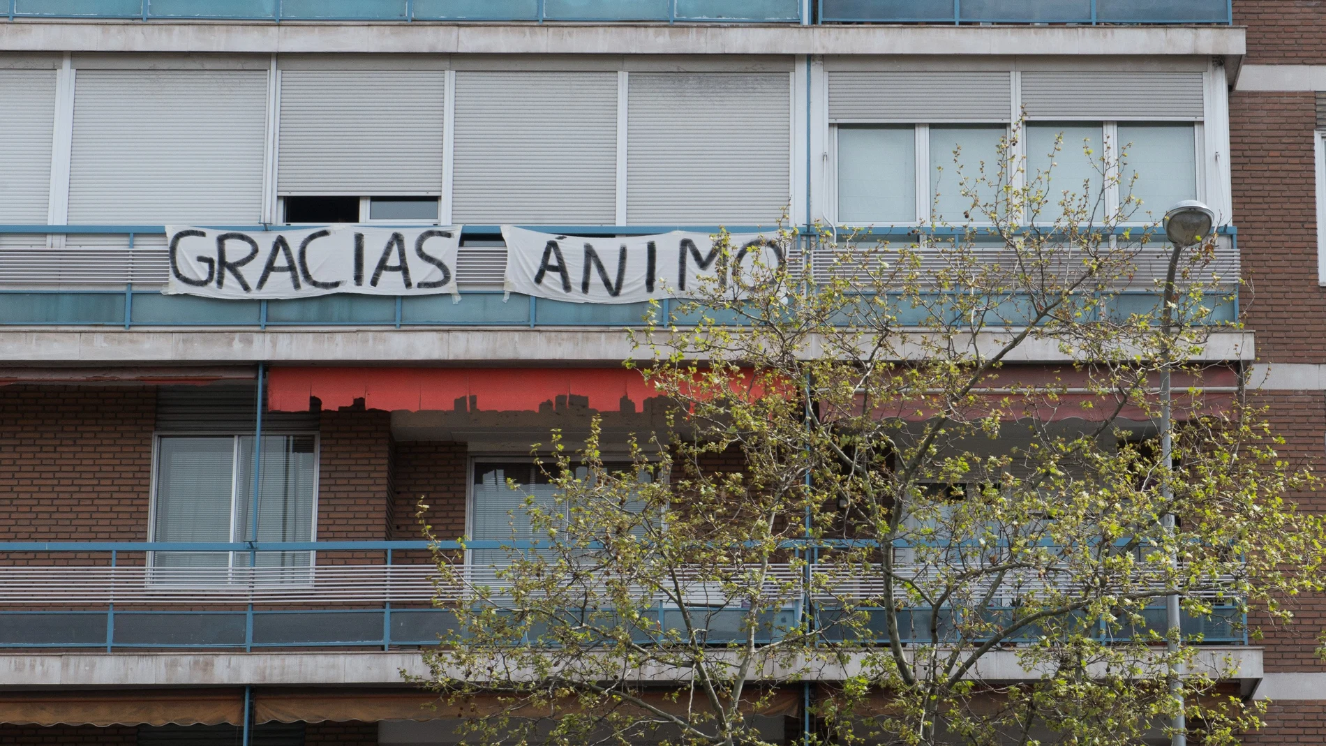 Pancarta en un balcón en la que se lee 'GRACIAS, ÁNIMO', durante el primer día laborable de la segunda semana desde que se decretó el estado de alarma en el país a consecuencia del coronavirus, en Madrid