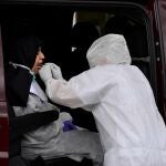Personal sanitario del Centro Periférico de Especialidades (Bola Azul) de Almería toma una muestra del material biológico de boca y nariz para la realización del test rápido del Covid-19 a una religiosa dentro de un automóvil