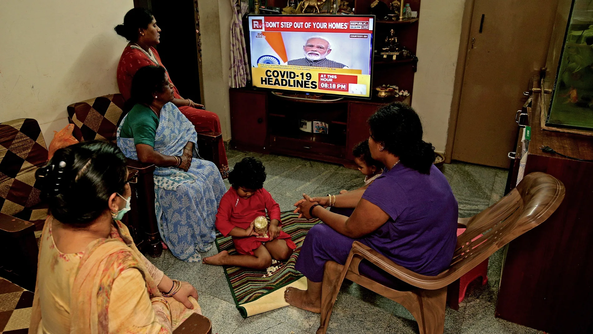 Una familia escucha el segundo discurso del primer ministro indio, Narendra Modi, en una semana sobre el coronavirus/EPA