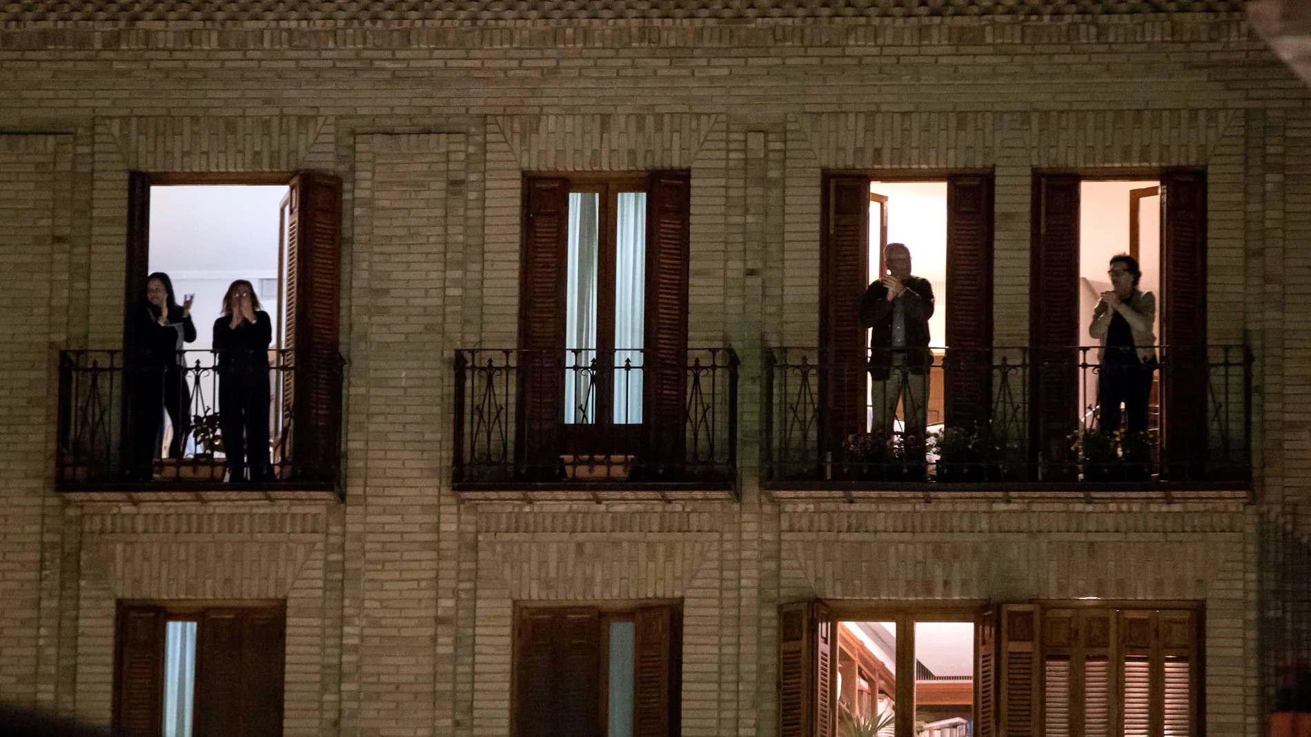 Varias personas aplauden desde los balcones de su casas la labor de los médicos y sanitarios por la crisis del coronavirus