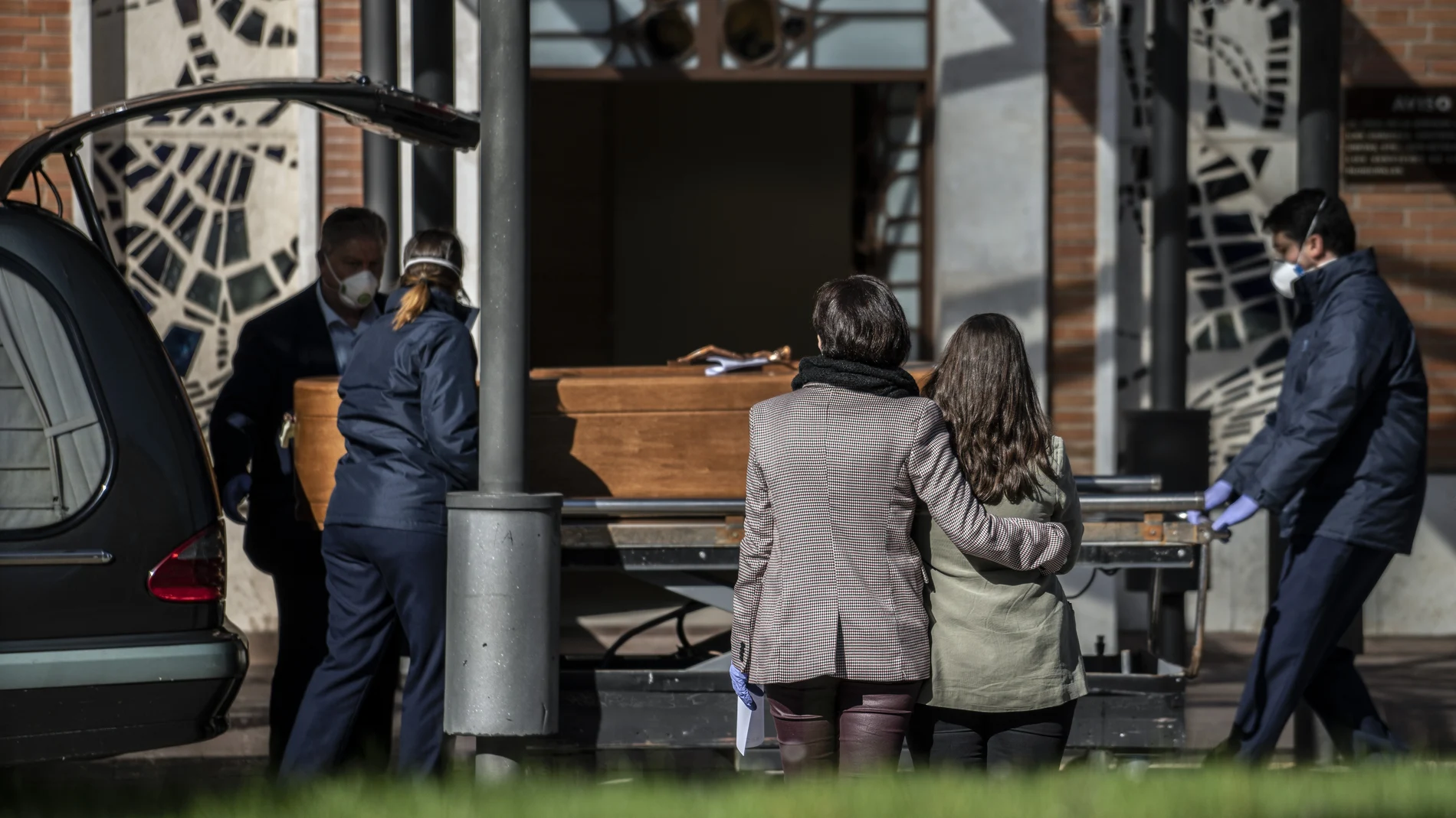 Familiares se despiden de una víctima del Covid-19 en el cementerio de la Almudena