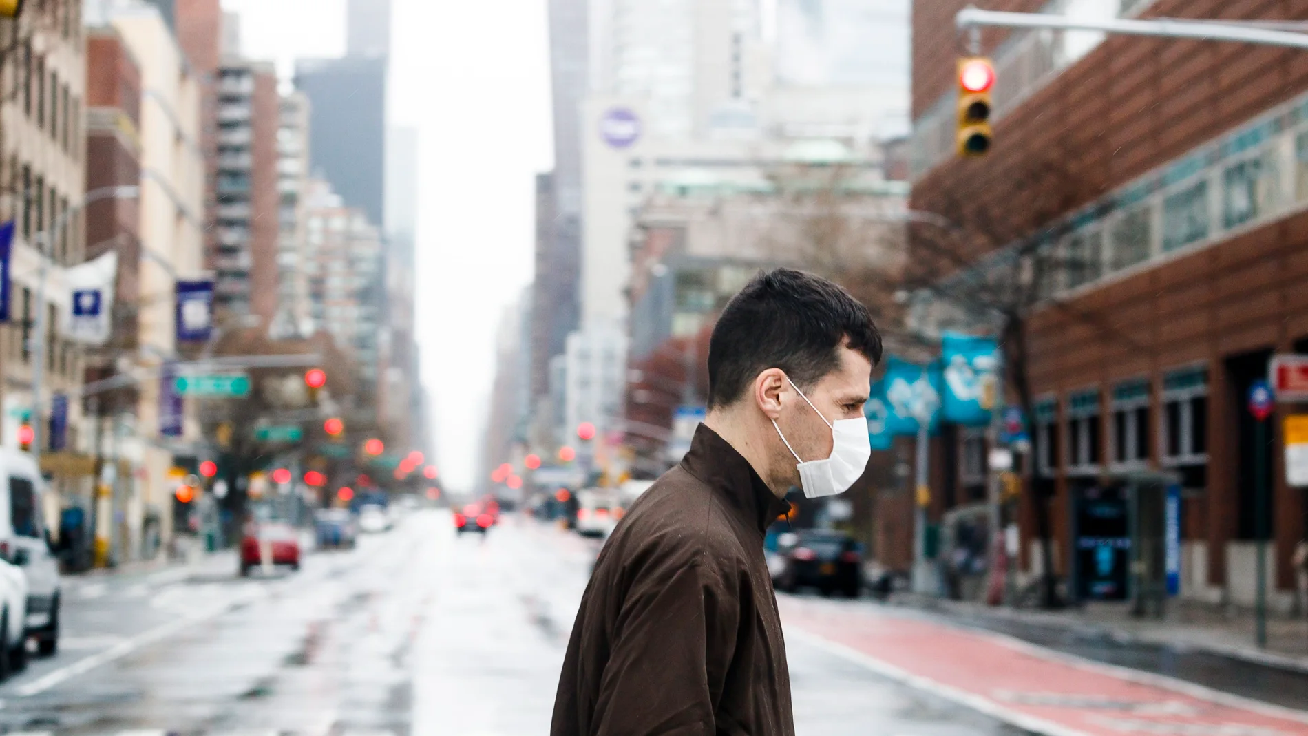 New York (United States), 28/03/2020.- A man in a protective mask crosses a quiet avenue in New York, New York, USA, on 28 March 2020. The city is continuing to deal with one of the country'Äôs largest outbreak of COVID-19 cases as the coronavirus spreads. The region has shutdown of all non-essential businesses in an effort to keep the city'Äôs hospital system from being overwhelmed with seriously ill COVID-19 patients. (Estados Unidos, Nueva York) EFE/EPA/JUSTIN LANE