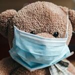 Oso de peluche con mascarilla quirúrgica mal ajustada. Así, no se pone una mascarilla.