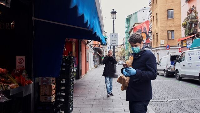 Un hombre espera su turno en una frutería del Mercado de Antón Martín en Madrid