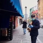 Un hombre espera su turno en una frutería del Mercado de Antón Martín en Madrid