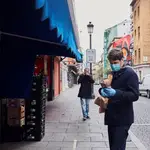 Un hombre espera su turno en una frutería del Mercado de Antón Martín en Madrid