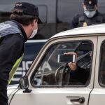 Agentes de la Policía Nacional realizan un control de tráfico con motivo del confinamiento decretado por el Estado