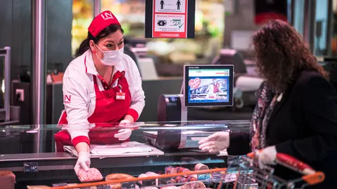 Un empleado y un cliente llevan mascarillas en un supermercado de Viena/EFE
