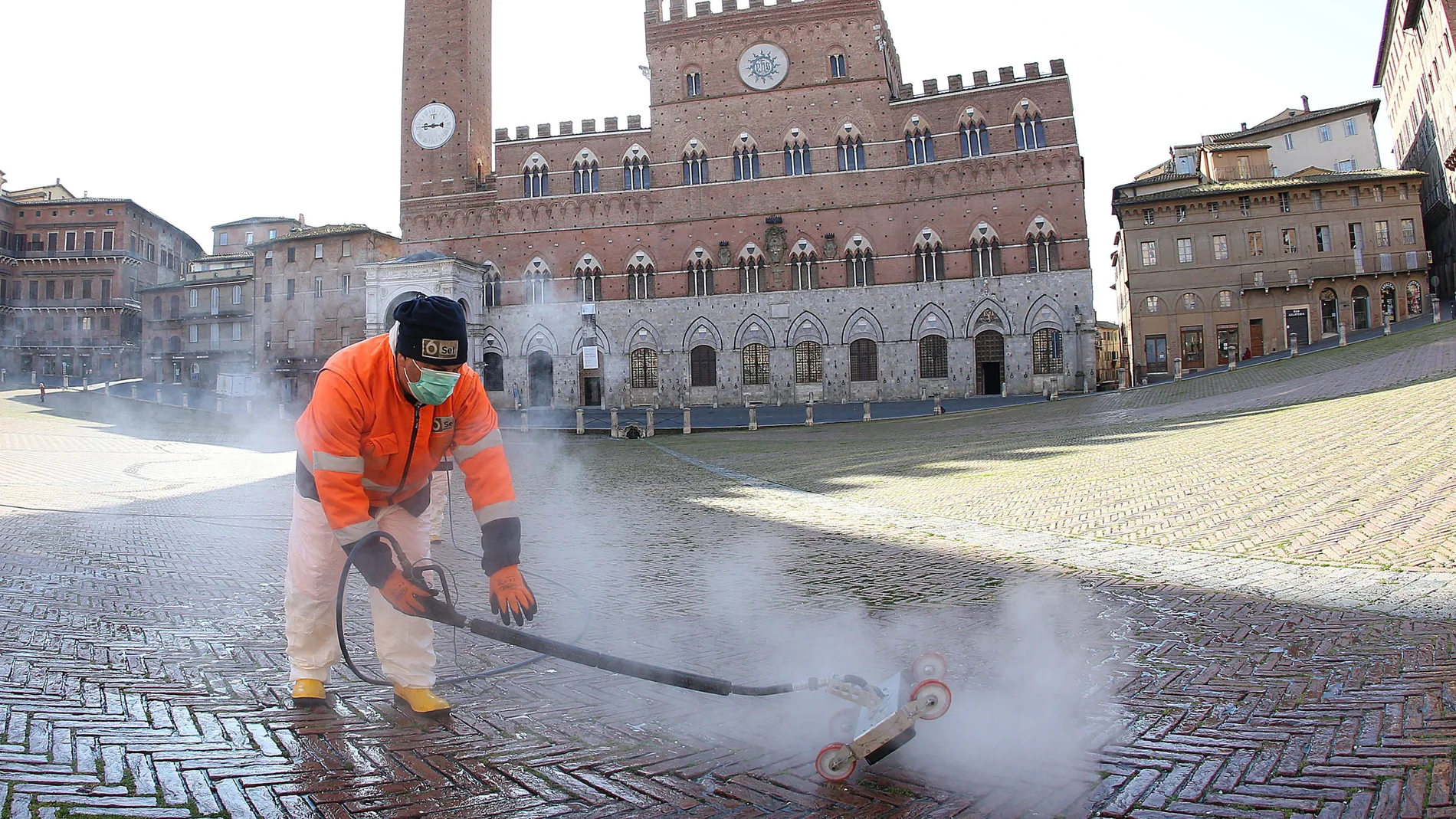 Un operario desinfecta la céntrica Piazza del Campo donde se celebra el Palio de Siena
