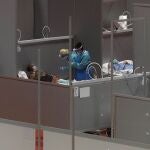Personal sanitario atiende a un paciente en el pabellón 9 del centro de exposiciones Ifema, reconvertido en hospital temporal.