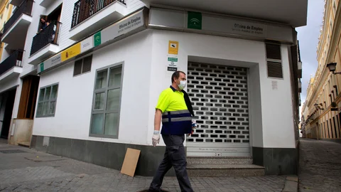 Un hombre pasando con mascarilla por una oficina del SAE en Sevilla