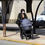 Una mujer con mascarilla y un carrito de bebé camina a la entra de un centro de salud en Sevilla