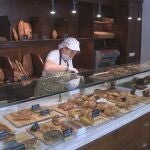 Una dependienta repone el producto en el Forn de Toni, cuyo gerente, Luis Montoya, ha explicado a EFE que la venta de pan en algunos hornos tradicionales valencianos ha caído hasta un 60 por ciento por el cambio de costumbres a la hora de comprar tras el confinamiento