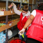 Voluntarios de la Cruz Roja colocan alimentos y productos para seguir prestando ayuda en su centro de operaciones en Mistala (Valencia) en plena crisis del coronavirus