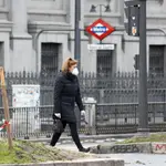 Una mujer con mascarilla pasea junto a la boca del metro de Banco de EspañaÓscar J.Barroso / Europa Press06/04/2020