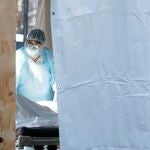 Un sanitario transporta a un fallecido por el Covid-19 a una de las morgues temporales del hospital Wyckoff Heights Medical en Brooklyn, Nueva York