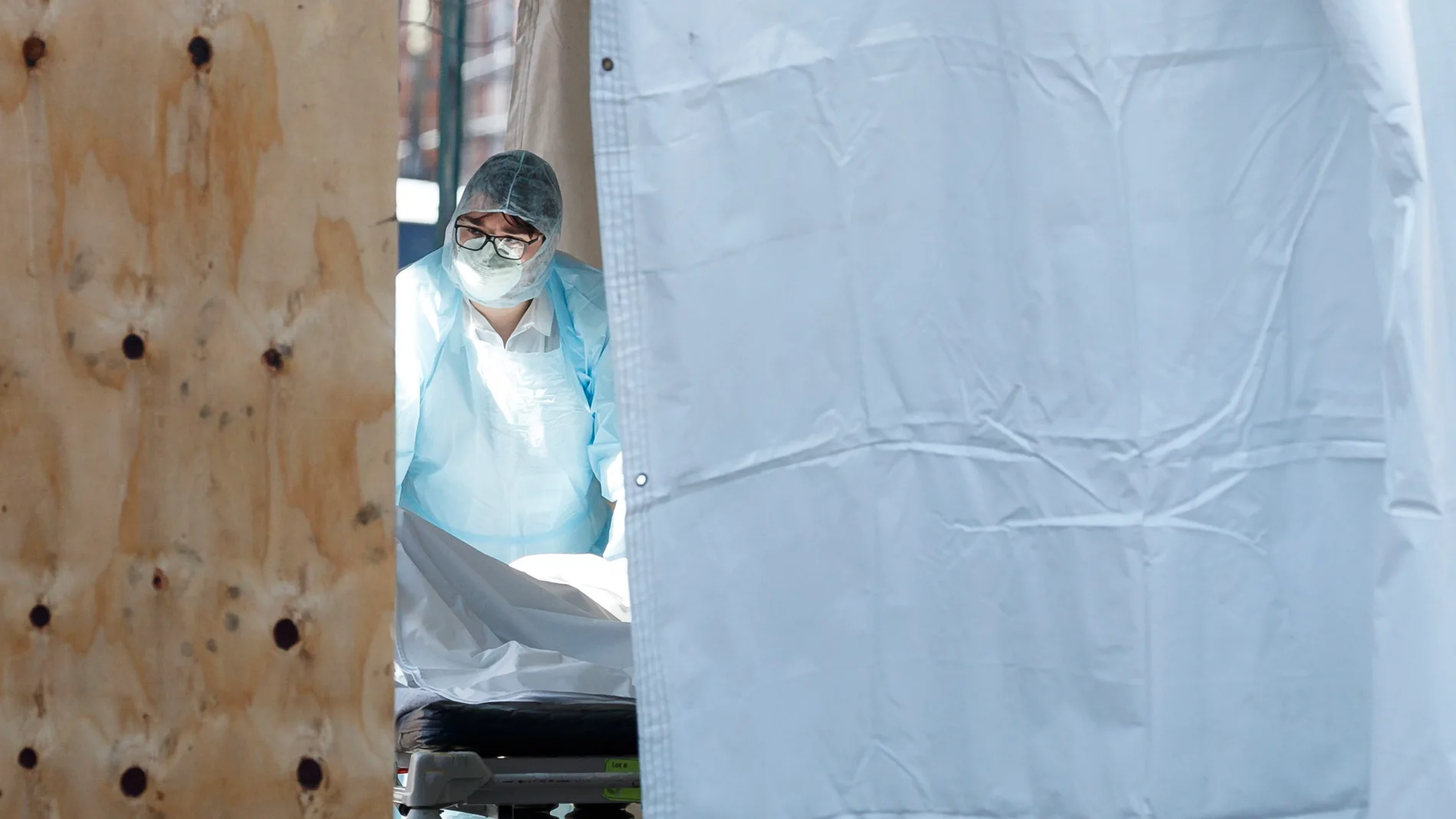 Un sanitario transporta a un fallecido por el Covid-19 a una de las morgues temporales del hospital Wyckoff Heights Medical en Brooklyn, Nueva York