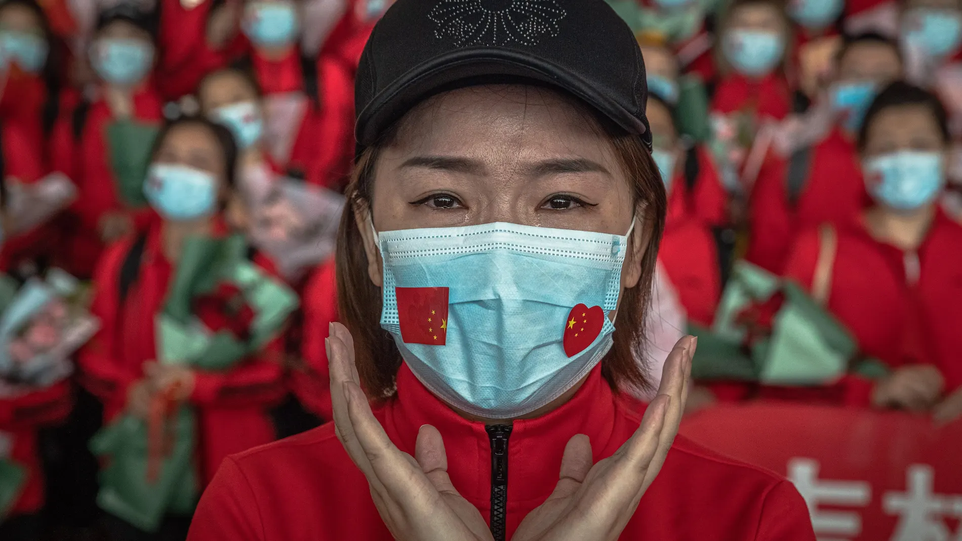 Una sanitaria del hospital de la Universidad de Jilin se emociona en el aeropuerto mientras aguarda para abandonar la ciudad tras levantarse el confinamiento en Wuhan (China), este miércoles