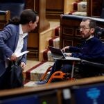 MADRID, 09/04/2020.- El vicepresidente segundo del Gobierno, Pablo Iglesias (i) conversa con el diputado de Unidas Podemos Pablo Echenique (d) durante el pleno celebrado este jueves en el Congreso para aprobar una nueva prórroga del estado de alarma, en un debate en el que también se abordará la nueva fase que se abrirá en las próximas semanas con el levantamiento progresivo de las restricciones a la movilidad por el coronavirus. EFE/Mariscal POOL