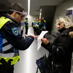 Una señora muestra su permiso a un agente en el metro de Oporto