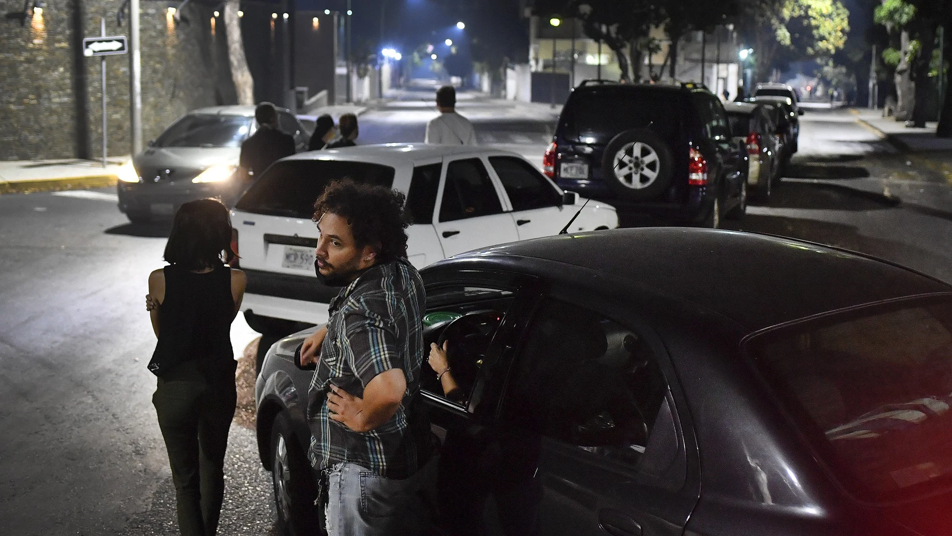 Conductores esperan fuera de sus vehículos a repostar gasolina en Caracas/AP
