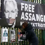 Una seguidora del pirata informático Julian Assange coloca un cartel en la verja de Woolwich Crown Court en Londres