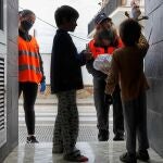 Miembros de Protección Civil, Guardia Urbana y voluntarios reparten monas de Pascua entre los niños de la localidad barcelonesa de Sant Fruitós de Bages, en Semana Santa.