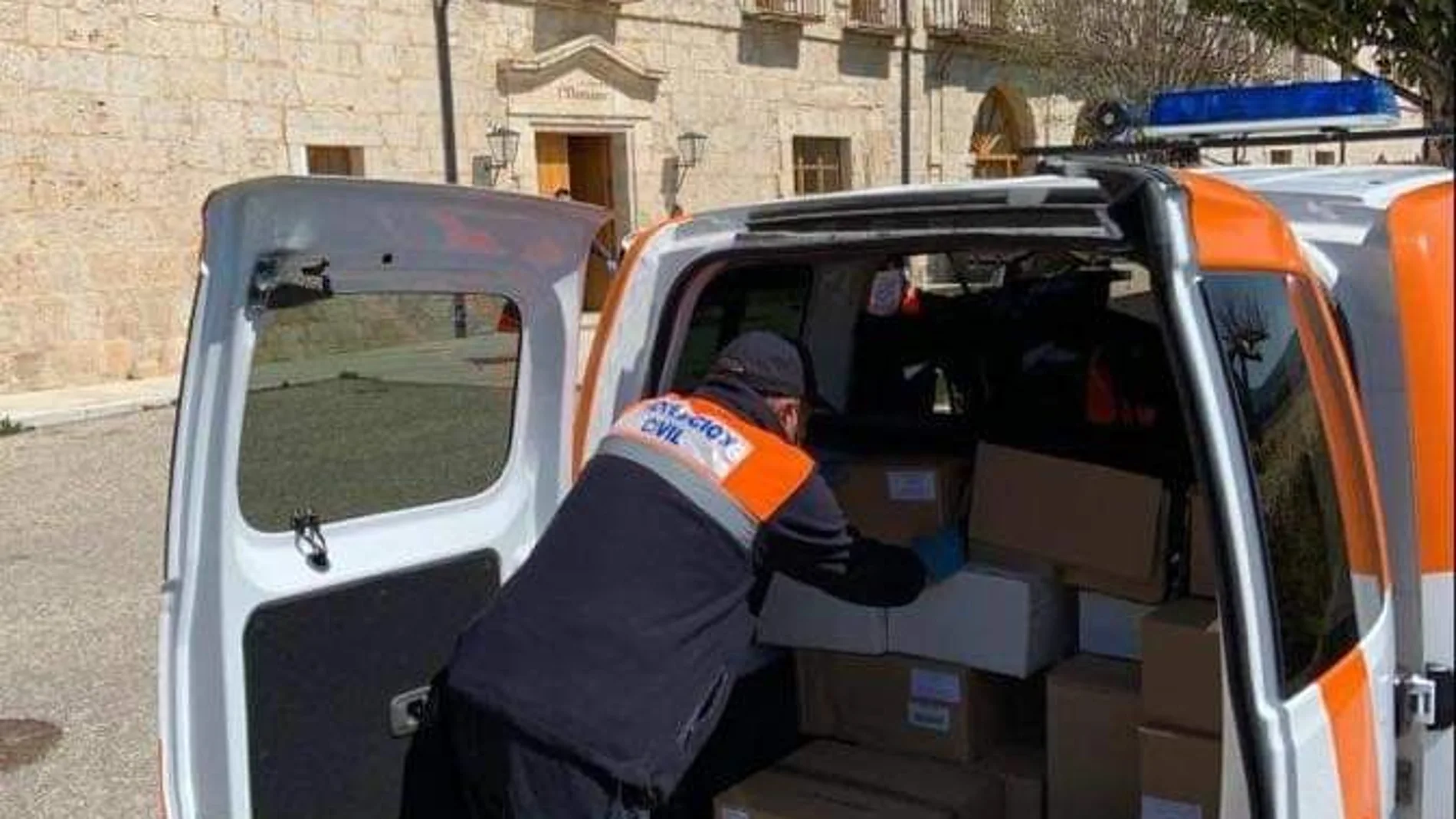 Un voluntario de Protección Civil reparte alimentos en Peñafiel (Valladolid) en estos tiempos de pandemia
