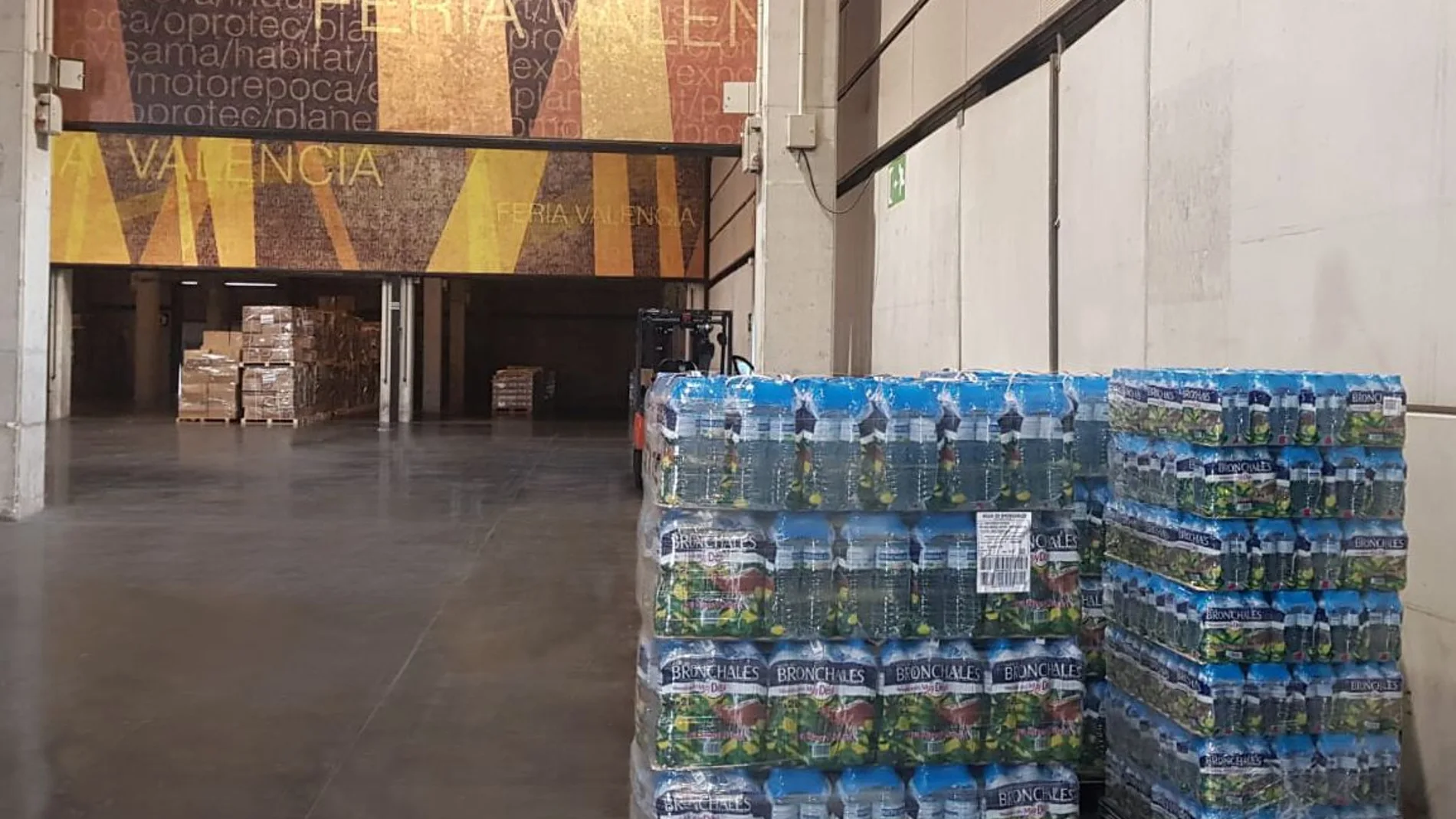 Mercadona entrega tres palets de botellas de agua mineral a los voluntarios sanitarios que descargan el material en Feria Valencia