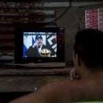 Un hombre observa la pantalla de un televisor la reaparición de Daniel Ortega, durante una transmisión de Cadena Nacional en Managua