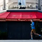 Un hombre corre por la avenida de los Campos Elíseos de París