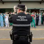 Un policía local y sanitarios del Hospital La Fe de Valencia, durante el aplauso diario en apoyo a todo el personal por su labor en la crisis del coronavirus, en una imagen de entrañable archivo