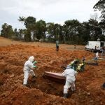 Gravediggers wearing protective clothing prepare to bury 78-year-old Lelito Jose Martins, who passed away due to the coronavirus disease (COVID-19), at the Parque Taruma cemetery in Manaus, Brazil April 17, 2020. REUTERS/Bruno Kelly