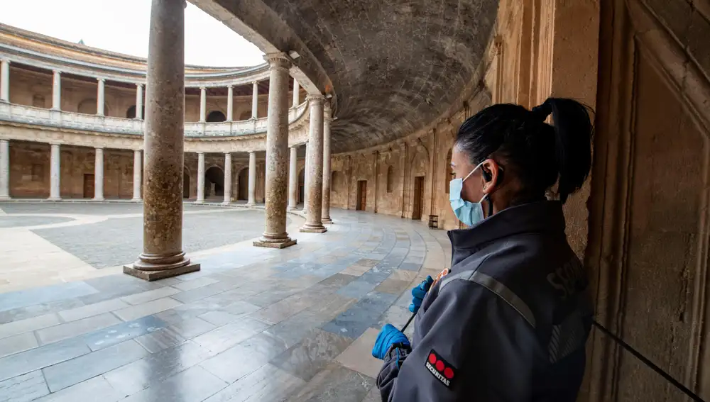 Un miembro de seguridad contempla el palacio de Carlos V de la Alhambra en Granada
