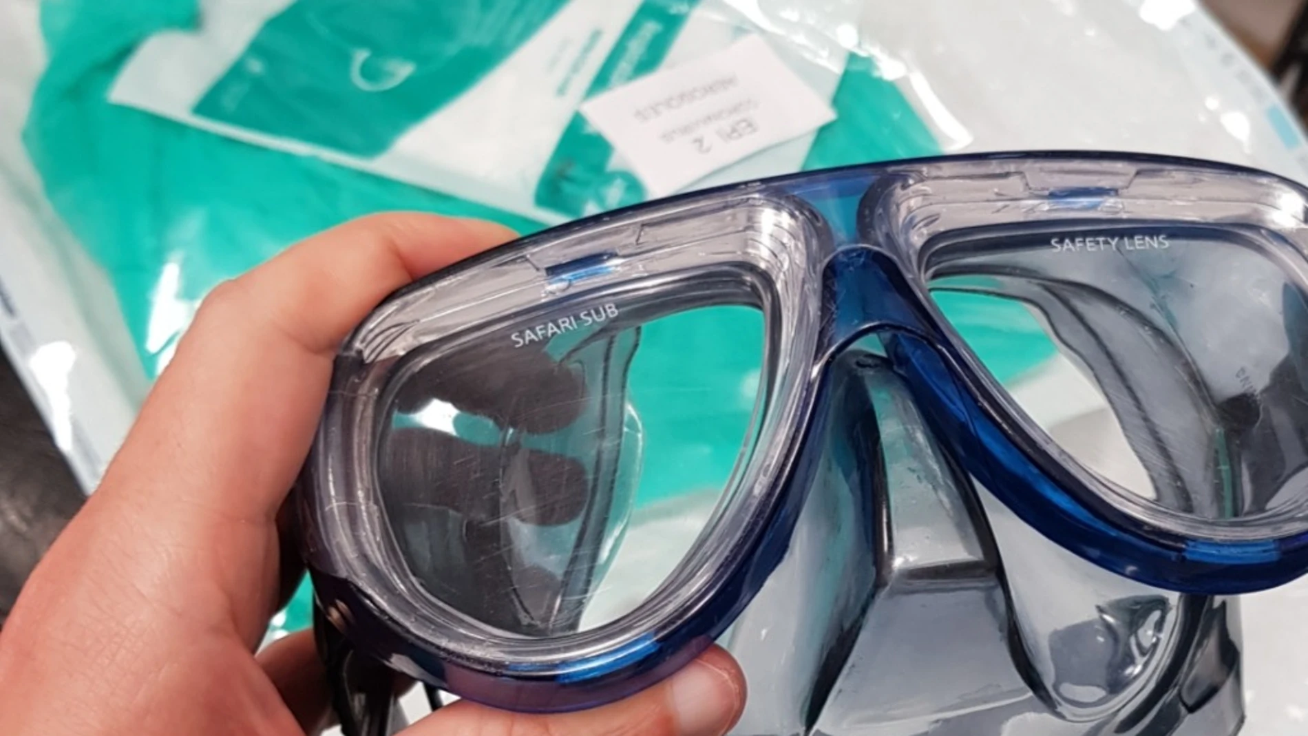 En la imagen se puede ver, además de las gafas de buceo, el envoltorio verde de las mascarillas defectuosas